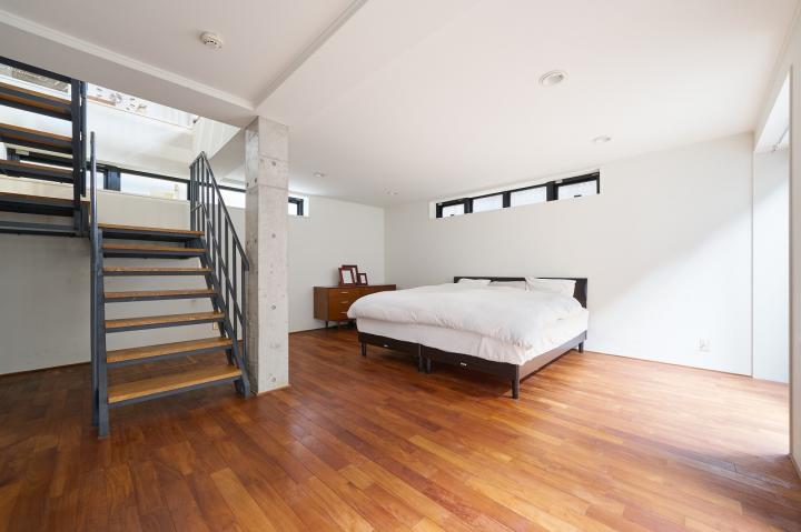 階段を下ると木・白を基調としたBedroom