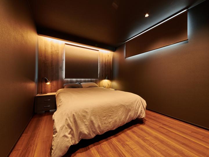 ■ウォールナット柄のフローリングと黒を基調としたクロスにより、シックな寝室空間を演出。